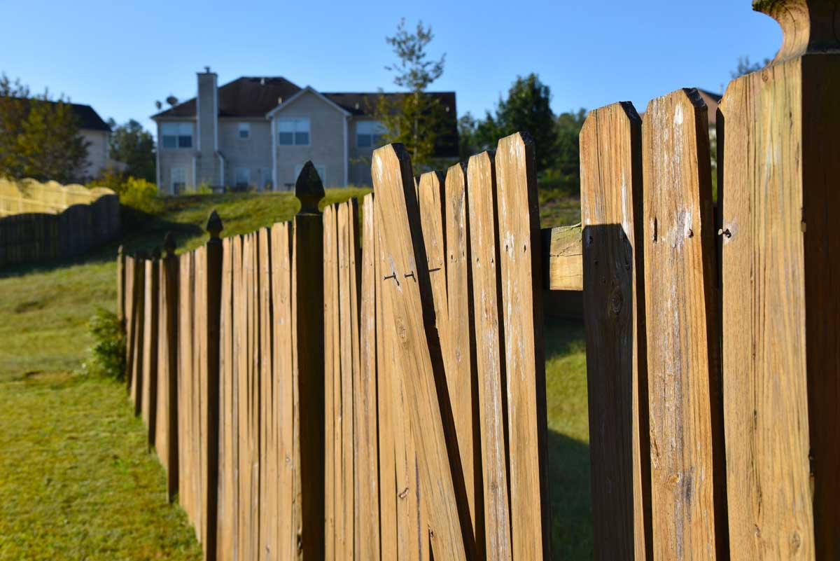 A wooden fence with slats falling off