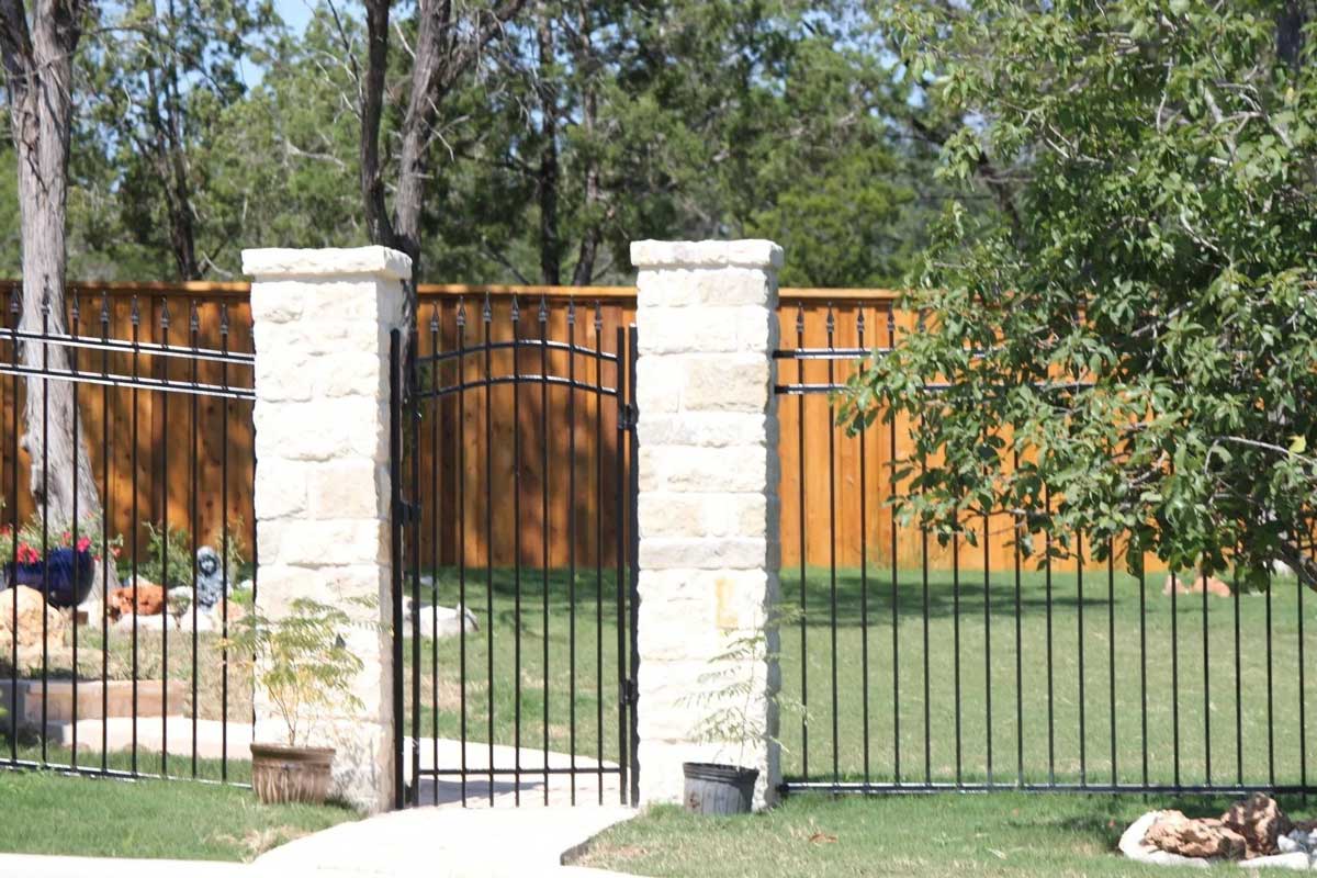 An iron bar gate with two stone columns framing the door