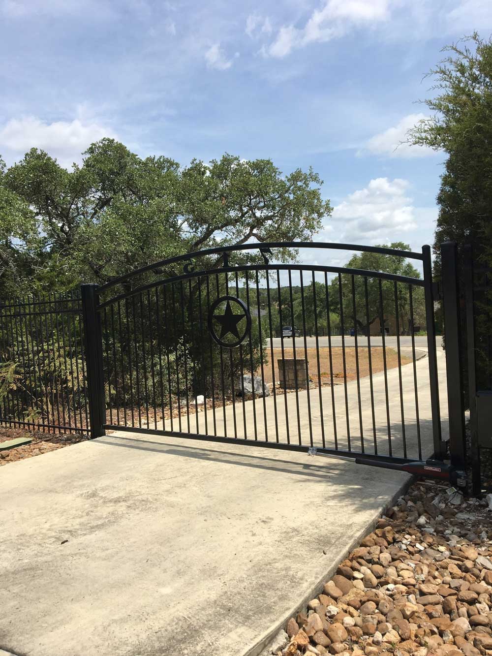 An arched iron gate with a large start in its center