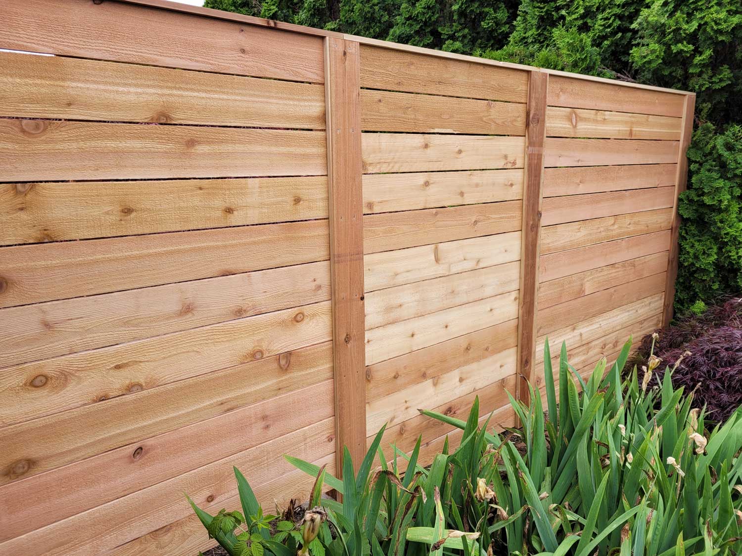 A wooden fence made out of light-brown planks