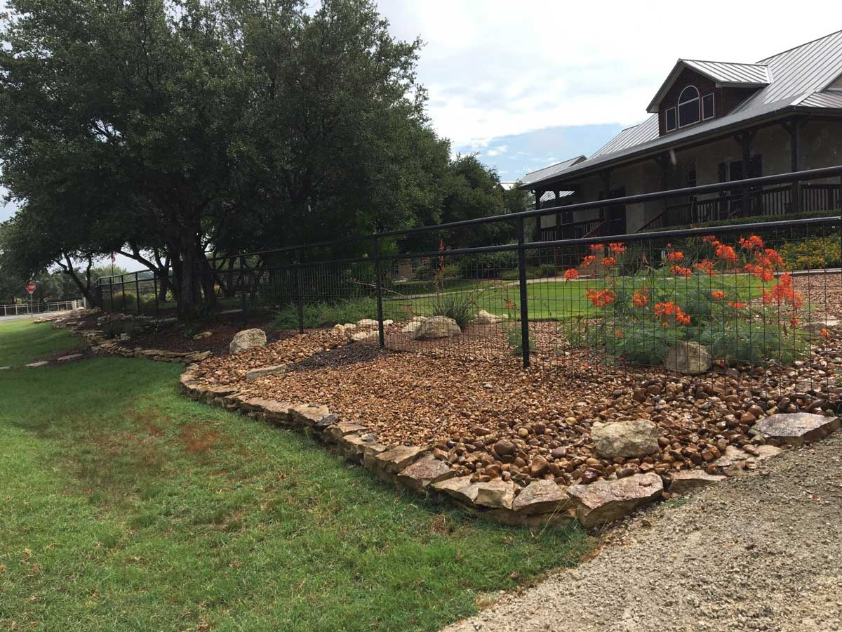 A wire fence going through the front of a cabin home's yard