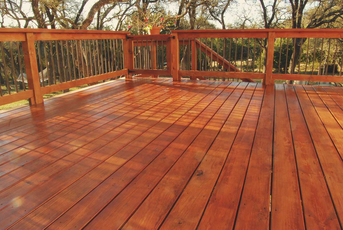 A stained wooden deck made of orange-brown wood